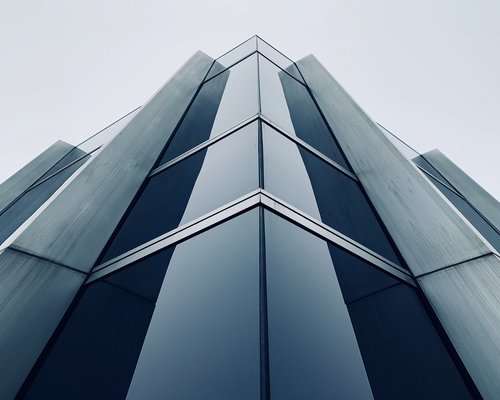 A modern corporate business district building glass facade reflecting standard office hours scenery