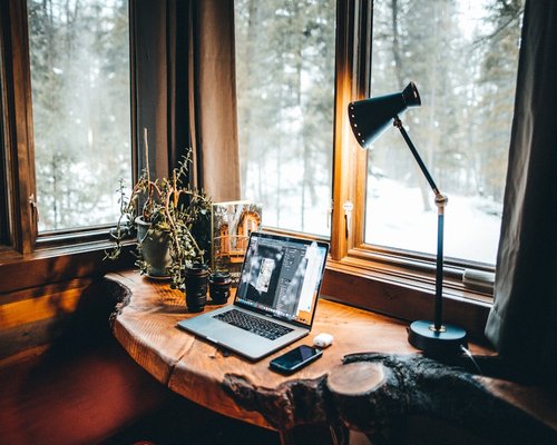 A cozy indoor dynamic desk corner setting with natural elements perfect for home based office work
