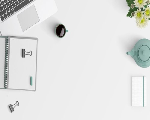 Close up of a modern flat desk layout with a closed elegant notebook and clean workspace styling